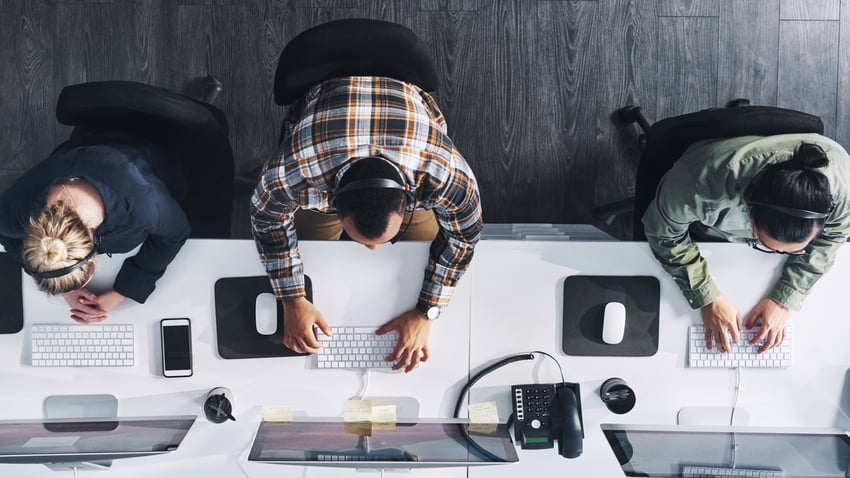 Foto en gran angular de un grupo de agentes de call center trabajando en una oficina